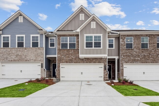 Exterior shot of Carlton Crossing, two story townhome with a private driveway and attached garage. - Carlton Crossing