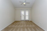 This single-floor residence offers a thoughtfully designed open-concept layout that seamlessly connects the living and kitchen areas. The spacious living room features soft carpeting, a ceiling fan, and a smooth flow into the kitchen, which serves as the heart of the home. The kitchen is outfitted with rich wood cabinetry, granite countertops, a tiled backsplash, stainless steel appliances including a refrigerator, electric range, and built-in microwave, plus a generous island with an undermount sink — all set atop warm hardwood-style flooring. Crown molding and track lighting add a polished touch to the space. The bedrooms are carpeted and generously sized, with vaulted ceilings, ceiling fans, and large windows that invite natural light and exterior views. The primary bedroom features a walk-in closet with built-in shelving and access to a private area, while additional bedrooms offer comfortable proportions with ample natural light. The bathroom is finished with wood-style flooring, a granite-topped vanity with warm wood cabinetry, and a full tub-shower combination with tile surround. Throughout, the home maintains a neutral, inviting palette with clean lines and quality finishes that create a comfortable and functional living environment.