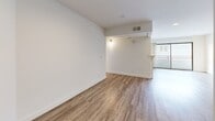 This 2-bedroom, 3-bathroom unit at 13719 Oxnard St, Unit 103 in Los Angeles, CA offers a well-designed single-floor layout with a clean, contemporary aesthetic throughout. Wood-look luxury vinyl flooring runs seamlessly across all rooms, lending warmth and continuity to the space.

The open living and dining area is a standout feature, highlighted by a central fireplace with a white surround that divides the two zones, recessed lighting, and a large sliding glass door that floods the room with natural light and opens onto a private balcony.

The kitchen is efficiently laid out with white shaker-style cabinetry, light stone countertops, a double stainless steel sink, stainless steel appliances, and a bold mosaic glass tile backsplash that adds a decorative focal point.

Both bedrooms are bright and well-proportioned, each featuring recessed lighting, windows for natural light, and sliding panel closets offering ample storage. The primary bedroom is generously sized with its own dedicated closet space.

Three bathrooms are finished with white vanities, large mirrors, wood-look flooring, and tub-shower combinations surrounded by elegant striped stone-look tile. A hallway connects the bedrooms and bathrooms, completing the functional and cohesive floor plan.