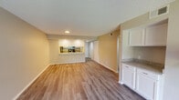 This single-floor residence offers a thoughtfully designed open-concept layout that connects the living, dining, and kitchen areas seamlessly. The living room serves as a central gathering space, highlighted by a classic fireplace, a ceiling fan, and large sliding glass doors that flood the room with natural light and provide outdoor views. Hardwood-style flooring runs throughout the main living areas, lending a clean and cohesive aesthetic.

The kitchen is accessible via a pass-through counter that overlooks the dining and living areas, creating an interactive and functional connection between spaces. Inside, the kitchen is equipped with stainless steel appliances — including a refrigerator, range, microwave, and dishwasher — complemented by granite countertops and crisp white cabinetry that maximize both storage and style.

The bedroom is a comfortable, naturally lit space featuring a ceiling fan, blinds-covered window, and the same hardwood-style flooring found throughout the unit. The bathroom is well-appointed with granite countertops, white cabinetry, a large vanity mirror, and a tub-shower combination. Textured ceilings are present throughout the space, adding a classic residential character. Overall, the unit presents a clean, move-in-ready environment with modern finishes.