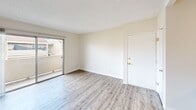 This 1-bedroom, 1-bathroom single-floor residence offers a thoughtfully designed layout that maximizes functionality across its compact footprint. The living room serves as the central gathering space, finished with light wood-style laminate flooring and a textured ceiling. A sliding glass door fills the room with natural light and opens directly to a private balcony, offering outdoor views of the surrounding area.

The kitchen is efficiently designed with white cabinetry providing ample storage both above and below the counters. A stainless steel gas range, double-basin sink, and warm-toned countertops complete the space, with light hardwood-style flooring tying it seamlessly into the adjoining living area. A peninsula counter separates the kitchen from the living room, creating an open, connected feel.

The bedroom is a comfortable, well-sized retreat featuring plush carpeting, a full-width sliding closet for generous storage, and a window that brings in natural light and outdoor views. A secondary carpeted room offers additional flexible space.

The bathroom includes a full soaking tub with an overhead shower, set against smooth, light-toned wall surrounds with chrome fixtures, creating a clean and functional bathing area. A hallway connects all rooms, contributing to the space's cohesive and efficient flow throughout.