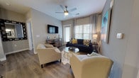 Located at 50 Central Island St on the sought-after Daniel Island in South Carolina, this single-floor residence offers a thoughtfully designed open-concept layout with modern finishes throughout. The kitchen is a standout feature, showcasing gray shaker-style cabinetry, white quartz countertops, a classic subway tile backsplash, and a full suite of stainless steel appliances. A large peninsula with bar seating and pendant lighting serves as both a functional workspace and a natural gathering point that flows seamlessly into the living area. The living room is bright and welcoming, with large windows that invite natural light, wood-look flooring, and a ceiling fan overhead. A built-in nook with open shelving provides additional storage and display space near the kitchen. The primary bedroom features an accent wall, a ceiling fan, closet storage, and direct access to an en-suite bathroom complete with a dual-sink vanity topped with granite counters and a large mirror. A second bedroom offers its own accent wall and generous closet space. The secondary bathroom includes a granite-topped vanity and a soaking tub with large-format tile surround. Wood-look flooring runs throughout, tying the space together with a cohesive, contemporary aesthetic.