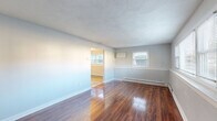 Located at 48 Oakdale St in Attleboro, Massachusetts, this two-floor home offers a well-organized layout with functional living spaces distributed across both levels. The main floor features gleaming hardwood flooring throughout the living areas, which are bathed in natural light from multiple windows. A staircase connects the levels, and baseboard heating is present throughout.

The kitchen is a standout space, equipped with warm oak cabinetry, granite countertops, a tile backsplash, and stainless steel appliances including a refrigerator, range, dishwasher, and built-in microwave. Light tile flooring and ample counter space make it highly functional. A half bathroom is conveniently located adjacent to the kitchen on the main floor, featuring a single vanity with oak cabinetry and a mirror with overhead lighting.

The upper floor hosts carpeted bedrooms, each offering natural light through multiple windows with views of the surrounding neighborhood and wooded areas. The bedrooms include built-in closets with bifold doors. A full bathroom on this level features tile flooring, a tub-shower combination with white subway tile surround, and a window for natural ventilation. The overall aesthetic throughout the home is clean and neutral, with light gray walls providing a versatile backdrop.