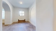 Located at 2110 Pickens St in Columbia, SC, this one-bedroom, two-bathroom unit offers a well-appointed single-floor layout with a distinctive blend of historic architectural character and modern finishes. Throughout the main living areas and bedroom, stained concrete floors lend an industrial-chic aesthetic, while crisp white walls and natural light filtering through arched-top and multi-pane windows brighten the interior. Elegant arched passageways connect the hallways, adding a timeless architectural detail that sets this unit apart. The spacious bedroom features a large multi-pane window that invites natural light, along with a dedicated closet. The kitchen is a standout, equipped with rich dark espresso cabinetry, granite-look countertops, a classic white subway tile backsplash, and a full suite of stainless steel appliances including a refrigerator, range, microwave, and dishwasher — all illuminated by recessed lighting. Both bathrooms are finished with dark shaker-style vanities, granite countertops, large-format tile flooring, and full tub-shower combinations, offering a cohesive and polished look. The floor plan flows intuitively through three hallway segments, connecting each space efficiently. This unit combines character-rich architecture with contemporary upgrades throughout.