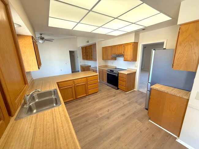 Kitchen has wood plank flooring, tons of counter space, cabients. - 13106 W Paintbrush Dr