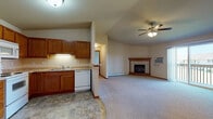 Located on Blue Heron Blvd in Fond du Lac, Wisconsin, this single-floor unit offers a well-designed, open-concept layout that maximizes both functionality and comfort. The living and kitchen areas flow seamlessly together, creating a spacious, connected feel. The living room is highlighted by a vaulted ceiling with a ceiling fan, a tile-surround fireplace serving as a central focal point, and a wall-mounted air conditioning unit. Sliding glass doors lead to a private balcony, allowing natural light to fill the space and providing outdoor views of the surrounding neighborhood.

The kitchen is outfitted with warm oak cabinetry, a full suite of white appliances including a refrigerator, electric range, and microwave, along with a double sink and tile-pattern flooring. A pantry closet adjacent to the kitchen adds convenient storage. A peninsula counter separates the kitchen from the main living area, enhancing the open layout while providing additional workspace.

The bedrooms are carpeted and generously sized. One bedroom features a ceiling fan, a closet, and sliding glass doors to the balcony. Another bedroom includes a walk-in closet with built-in shelving. A third room offers a bright window and baseboard heating. The bathroom includes a tub/shower combination, a vanity with storage, and tile-pattern flooring, completing this practical and comfortable single-level home.