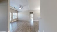 Located at 2506 Hope Way Lane in Charlotte, NC, this well-appointed single-story home offers three bedrooms and two bathrooms within a thoughtfully designed floor plan. The living room is a standout space, featuring a tray ceiling, a ceiling fan, and neutral gray walls that complement the warm hardwood-style flooring found throughout the main living areas. Natural light flows in through multiple windows dressed with blinds, and a glass door provides direct outdoor access, enhancing the open and airy feel of the space.

The kitchen is positioned at the heart of the home and features dark cabinetry, granite-style countertops, a raised breakfast bar, and pendant lighting overhead — offering both functionality and style. Adjacent to the kitchen, the dining area is highlighted by a classic chandelier and continued hardwood-style flooring.

The bedrooms are carpeted for comfort, each offering natural light through large windows and ample closet space. The primary bedroom includes a ceiling fan and connects to its own bathroom, which features dark vanity cabinetry, tile flooring, and a glass-enclosed shower. The second bathroom offers a similar vanity design along with a tub-shower combination.

A dedicated laundry room with side-by-side washer and dryer hookups adds everyday convenience, rounding out this practical and attractively finished home.