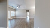 Located at 2506 Hope Way Lane in Charlotte, NC, this well-appointed single-story home offers three bedrooms and two bathrooms within a thoughtfully designed floor plan. The living room is a standout space, featuring a tray ceiling, a ceiling fan, and neutral gray walls that complement the warm hardwood-style flooring found throughout the main living areas. Natural light flows in through multiple windows dressed with blinds, and a glass door provides direct outdoor access, enhancing the open and airy feel of the space.

The kitchen is positioned at the heart of the home and features dark cabinetry, granite-style countertops, a raised breakfast bar, and pendant lighting overhead — offering both functionality and style. Adjacent to the kitchen, the dining area is highlighted by a classic chandelier and continued hardwood-style flooring.

The bedrooms are carpeted for comfort, each offering natural light through large windows and ample closet space. The primary bedroom includes a ceiling fan and connects to its own bathroom, which features dark vanity cabinetry, tile flooring, and a glass-enclosed shower. The second bathroom offers a similar vanity design along with a tub-shower combination.

A dedicated laundry room with side-by-side washer and dryer hookups adds everyday convenience, rounding out this practical and attractively finished home.