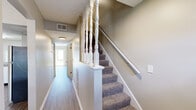 Located at 940 University Woods Dr in New Albany, Indiana, this two-story home offers a thoughtfully organized layout spread across two floors. The main level features a spacious living room with wood-look luxury vinyl plank flooring that flows throughout, bathed in natural light from a sliding glass door that opens to a view of the surrounding greenery. The kitchen is well-equipped with white shaker-style cabinetry, granite countertops, stainless steel appliances including a range, dishwasher, and refrigerator, complemented by a drop ceiling with flush lighting and durable LVP flooring. Hallways on the main floor provide seamless connectivity between rooms. Upstairs, the two bedrooms are finished with plush wall-to-wall carpeting and neutral toned walls, creating a comfortable and restful atmosphere. The generously sized primary bedroom features a built-in closet with louvered bifold doors, providing ample storage. The second bedroom also benefits from natural light through a window with blinds. A full bathroom serves the upper level. A staircase connects both floors efficiently. Throughout the home, clean white trim, neutral paint tones, and consistent finishes contribute to a cohesive and move-in-ready aesthetic.