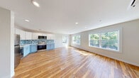 Located at 111 E Seneca St in Manlius, NY, this thoughtfully designed one-bedroom, one-bathroom residence offers a comfortable and modern living experience across a single floor. Rich, warm-toned hardwood flooring flows consistently throughout every room, lending a cohesive and inviting character to the entire space.

The open kitchen and living area serves as the heart of the home. The kitchen is outfitted with stainless steel appliances, including a refrigerator, range, microwave, and dishwasher. Two-toned cabinetry — white upper cabinets paired with soft powder-blue lower cabinets — is complemented by clean white countertops and a striking blue-gray mosaic tile backsplash. Recessed lighting illuminates the space efficiently.

The living area benefits from large windows that flood the room with natural light, offering views of the surrounding greenery. A ceiling fan adds both comfort and style to the bedroom, which also features a double closet and a window with outdoor views. Clean white Shaker-style doors are found throughout.

The bathroom is finished with a white vanity, a well-lit mirror, and continuing hardwood flooring. A utility room provides additional functional space. Overall, this residence presents a clean, modern aesthetic with quality finishes and ample natural light.
