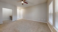 Located at 21393 IH-35 N in Kyle, TX, this one-bedroom, one-bathroom unit offers a thoughtfully arranged single-floor layout that makes efficient use of its space. The combined kitchen and living area forms the heart of the home, anchored by rich hardwood-style flooring that flows throughout. The kitchen is fully equipped with light wood cabinetry, a complete suite of white appliances including a range, microwave, refrigerator, and dishwasher, and a peninsula counter that provides additional workspace and a natural transition into the living area. The living room is open and functional, featuring a ceiling fan and neutral wall tones that create a clean, versatile backdrop. The spacious bedroom is carpeted for comfort and includes a ceiling fan, two windows that bring in ample natural light, and access to two closets, providing generous storage. The full bathroom is finished with warm hardwood-style flooring, light wood vanity cabinetry, a large mirror, stylish overhead lighting, and a full shower-tub combination. Clean lines, neutral finishes, and consistent design details throughout give this unit a cohesive and move-in-ready feel.