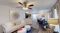 Located at 1301 E Dogwood Dr in Mebane, NC, this well-appointed single-floor residence offers a thoughtfully designed layout that balances comfort and functionality throughout. The open-concept living area serves as the heart of the home, featuring durable wood-look flooring, a ceiling fan with light fixture, and a bright, welcoming atmosphere. A peninsula counter seamlessly connects the living space to the kitchen, which is outfitted with dark wood cabinetry, white countertops, and a full suite of black appliances including a refrigerator, range, built-in microwave, and dishwasher. Adjacent to the living area, the dedicated dining space features warm accent walls and natural light from multiple windows, providing a comfortable setting for everyday meals. The bedrooms offer plush carpeted flooring and windows that bring in natural light, creating a relaxing retreat. Two bathrooms serve the residence, each finished with dark wood vanities, white countertops, large mirrors, and tile-style flooring. Throughout the home, consistent design choices — including neutral wall tones, wood-look flooring in main areas, and ample natural light — create a cohesive and inviting living environment well-suited for comfortable daily living in Mebane, NC.
