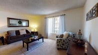 Located at 4900 E Fifth St in Tucson, Arizona, this single-floor residence offers a well-organized layout designed for comfortable everyday living. The living room serves as the heart of the home, featuring plush carpeting, large windows with vertical blinds and grommet-top curtains that invite natural light and views of the surrounding outdoor greenery, and a textured ceiling throughout.

The dining area is distinguished by warm wood-look flooring, a ceiling fan with lighting, and ample wall space that adds a welcoming character to mealtimes. Adjacent to the dining room, the galley-style kitchen is efficiently designed with dark wood cabinetry, light countertops, wood-look flooring, and a full suite of appliances including an electric range, refrigerator, and dishwasher.

The primary bedroom offers carpeted flooring, a window for natural light, and direct access to a dedicated walk-in closet. A second carpeted bedroom, currently configured as a home office, provides a quiet and functional workspace with its own window and generous wall space. The full bathroom features a dark wood vanity, stone-look countertop, a large mirror, and a shower-tub combination with wood-look flooring, completing this practical and comfortable Tucson residence.