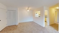 This single-floor residence offers a practical and well-organized layout designed for comfortable everyday living. The spacious living area is finished with neutral-toned carpet and features a ceiling fan overhead, along with a large sliding glass door fitted with vertical blinds that allows natural light to fill the room. A pass-through opening connects the living space directly to the kitchen, promoting an open and connected feel.

The kitchen is efficiently arranged in an L-shaped configuration, featuring light wood cabinetry with ample upper and lower storage, dark laminate countertops, a stainless steel sink, and white appliances including a gas range, over-the-range microwave, refrigerator, and dishwasher. The floor is finished in neutral tile.

The bedrooms are carpeted and bright, each offering natural light through windows with blinds and equipped with reach-in closets featuring louvered bifold doors and built-in shelving. The rooms provide a clean, open canvas adaptable to various furniture arrangements.

Two full bathrooms serve the residence, each finished with small-format white floor tile, a light wood vanity with an integrated sink, a framed mirror, and a full bathtub with tiled surround. Both bathrooms maintain a clean, functional aesthetic consistent with the overall neutral palette of the home.