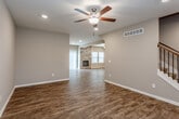 Located at 21322 W 65th St in Shawnee, Kansas, this three-floor home offers a well-designed layout with consistent finishes throughout. The main living area features rich wood-look flooring, recessed lighting, and a ceiling fan, creating a bright and comfortable atmosphere. A staircase with a dark wood handrail and wrought iron balusters connects the levels, adding a refined architectural detail.

The kitchen is a standout space, equipped with white shaker cabinetry, granite countertops, stainless steel appliances, and a central island with pendant lighting above. Wood-look flooring continues here, complementing the warm, neutral color palette found throughout the home.

Bedrooms are carpeted for comfort and feature generous walk-in closets. The bathrooms are finished with white vanity cabinetry, large mirrors, tile flooring, and clean white fixtures. One bathroom includes a tub-shower combination, while another offers a wide vanity with walk-in closet access.

A dedicated laundry room includes a washer and dryer with overhead cabinetry for added storage. The unfinished basement spans a substantial area with framed walls and rough-in plumbing already in place, offering significant potential for future customization and additional living space.