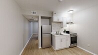 Located at 1016 McGowan Dr in Little Rock, AR, this compact one-bedroom, one-bathroom unit is thoughtfully designed to maximize every square foot across a single floor. Light wood-tone flooring runs throughout, creating a cohesive and clean aesthetic from room to room.

The combined dining, kitchen, and living area forms the heart of the unit. The kitchen is well-appointed with white shaker-style cabinetry, a subway tile backsplash, a stainless steel refrigerator, an electric range, and an under-cabinet range hood. A single-basin sink with a single-handle faucet completes the functional workspace.

A hallway connects the main living area to the private quarters, leading to the bedroom and bathroom. The bedroom is a cozy, well-proportioned space featuring a window that brings in natural light and a built-in closet with wire shelving for organized storage. Neutral-toned walls and the same light wood flooring maintain a calm, unified feel.

The bathroom features a white vanity with ample drawer storage, a large mirror, and a shower-tub combination. Clean lines and a neutral color palette give the bathroom a tidy, practical finish. Overall, the unit presents a straightforward, move-in-ready layout suited for efficient, comfortable living.