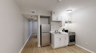 Located at 1016 McGowan Dr in Little Rock, AR, this compact one-bedroom, one-bathroom unit is thoughtfully designed to maximize every square foot across a single floor. Light wood-tone flooring runs throughout, creating a cohesive and clean aesthetic from room to room.

The combined dining, kitchen, and living area forms the heart of the unit. The kitchen is well-appointed with white shaker-style cabinetry, a subway tile backsplash, a stainless steel refrigerator, an electric range, and an under-cabinet range hood. A single-basin sink with a single-handle faucet completes the functional workspace.

A hallway connects the main living area to the private quarters, leading to the bedroom and bathroom. The bedroom is a cozy, well-proportioned space featuring a window that brings in natural light and a built-in closet with wire shelving for organized storage. Neutral-toned walls and the same light wood flooring maintain a calm, unified feel.

The bathroom features a white vanity with ample drawer storage, a large mirror, and a shower-tub combination. Clean lines and a neutral color palette give the bathroom a tidy, practical finish. Overall, the unit presents a straightforward, move-in-ready layout suited for efficient, comfortable living.