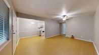 Located at 1330 E 48th Pl in Tulsa, Oklahoma, this single-floor, 1-bedroom, 2-bathroom home offers a thoughtfully organized layout with a comfortable and functional design throughout. Light gray walls, white trim, and ceiling fans are consistent features across the main living areas, contributing to a clean and cohesive aesthetic.

The open living room is finished with light wood-tone laminate flooring and is anchored by a ceiling fan with integrated lighting. It flows naturally into the combined dining and kitchen area, which is separated by a subtle half-wall detail. The kitchen is laid out in a galley style, featuring white cabinetry, subway tile backsplash, marble-look countertops, and a full suite of white appliances including an electric range, over-the-range microwave, and refrigerator. A pendant light fixture illuminates the adjacent dining space.

The bedroom offers generous proportions with soft carpet underfoot, a ceiling fan, natural light from a window, and access to two closets — including a walk-in closet. Built-in dresser drawers are integrated into the bedroom, adding practical storage. The hallway connects the bedroom to both bathrooms, one of which features a full tub-shower combination with a window providing natural light. The home also includes a dedicated hallway for smooth circulation between all spaces.