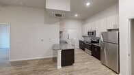 This 590 square foot, single-floor apartment in Charlotte, NC offers a thoughtful layout maximizing its compact space. The modern kitchen is a highlight, featuring stainless steel appliances, granite countertops, and a combination of white and dark wood cabinetry. A small island provides additional counter space and separates the kitchen from the living area.

The bedroom, measuring 130 square feet, includes a ceiling fan and window, allowing for natural light and air circulation. The bathroom boasts a full-sized tub with shower, and a single vanity with ample counter space. In-unit laundry facilities add convenience, with full-sized washer and dryer.

Throughout the apartment, wood-look vinyl flooring creates a cohesive, contemporary feel. Recessed lighting in the kitchen and living areas provides bright, even illumination. The neutral color palette of whites and grays offers a blank canvas for personalization.

Despite its compact size, the apartment's layout feels open and airy, with clear sight lines between rooms. The single floor plan and absence of stairs make this unit accessible and easy to navigate. Located at 1840 Ripple Way in Charlotte's 28262 zip code, this apartment combines modern amenities with efficient use of space.
