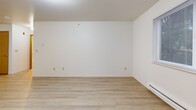Located at 625 S Stillaguamish Ave in Arlington, WA, this one-bedroom, one-bathroom unit offers a practical and well-organized single-floor layout. The combined living, dining, and kitchen area forms the heart of the home, finished with light wood-style flooring that carries a clean, cohesive look throughout. The kitchen features warm honey-toned cabinetry, a full suite of white appliances including a refrigerator, electric range, and dishwasher, along with ample counter and storage space. The living and dining area is bright and open, benefiting from natural light through a large window and a sliding glass door that connects to the outdoors. A baseboard heating system ensures year-round comfort. The bedroom is carpeted for warmth and comfort, includes a window with outdoor views, and is served by two closets for generous storage. The bathroom is clean and functional, featuring a full tub-shower combination with a grab bar and curtain rod. White walls and consistent ceiling lighting throughout the unit create a bright, neutral canvas. The layout is efficient and straightforward, making practical use of the available space.