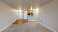 This 2-bedroom, 2-bathroom unit at 3307 E 55th Ave in Spokane, WA offers a well-designed single-floor layout that balances comfort and functionality. The open-concept living area seamlessly connects the dining room, kitchen, and living room, creating a spacious and cohesive gathering space. The kitchen is well-equipped with warm wood cabinetry, light countertops, black appliances including a refrigerator, electric range, microwave, and dishwasher, and durable hardwood-style flooring. A peninsula with a built-in sink adds both workspace and a natural division between the kitchen and living areas. The living room features soft carpeting and a sliding glass door that opens onto a private balcony, inviting natural light and outdoor views. Both bedrooms are carpeted and include natural light from windows, baseboard heating, and closet access — with the primary bedroom offering generous proportions. The two bathrooms feature warm wood vanities with storage, tile-style flooring, and clean, functional finishes. Additional highlights include in-unit laundry, four closets for abundant storage, and a hallway connecting the private spaces. The neutral color palette throughout gives the unit a clean, move-in ready appeal.