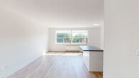 Located at 4979 Bathurst Street in North York, Toronto, this 2-bedroom, 1-bathroom unit offers a thoughtfully designed single-floor layout with a clean, contemporary aesthetic. Light wood laminate flooring runs throughout, lending warmth and continuity to the space.

The kitchen is a standout feature, showcasing white shaker-style cabinetry with ample upper and lower storage, a subway tile backsplash, dark countertops, and a full suite of stainless steel appliances including a refrigerator, electric range, over-the-range microwave, and dishwasher. A central island provides additional prep space and casual dining potential, while the open-concept layout connects seamlessly to the living area.

The two bedrooms are bright and airy, with large windows that invite natural light and offer views of surrounding greenery. The primary bedroom offers a comfortable footprint with room for a full bedroom suite. Each bedroom features the same light flooring, maintaining a cohesive feel throughout.

The bathroom is finished with classic white subway tile surrounding the soaking tub and shower, complemented by stone-effect floor tiles, a grey vanity with an integrated sink, and a well-placed wall sconce above the mirror.

The overall palette — white walls, light flooring, and neutral accents — creates a fresh, modern ambiance well-suited to urban living in Toronto.