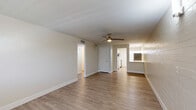 Located at 1039 N Alamo Ave in Tucson, AZ, this 2-bedroom, 1-bathroom unit offers a clean, modern aesthetic across a single-floor layout. Light wood-style luxury vinyl flooring flows consistently throughout the space, complementing the crisp white walls and trim. A distinctive painted brick wall adds texture and character to several rooms, lending the unit a subtle industrial charm.

The combined kitchen and living area serves as the heart of the home. The kitchen is thoughtfully designed with white shaker-style cabinetry, light stone countertops, and stainless steel appliances including a refrigerator, dishwasher, and range. A ceiling fan in the adjacent living area promotes airflow, while a window allows natural light to fill the space.

Both bedrooms are bright and comfortably sized. The primary bedroom offers a sliding closet and access to the hallway, while the second bedroom features painted brick accent walls and windows that invite natural light. Each room benefits from the consistent, neutral palette that makes the space feel open and adaptable.

The full bathroom is clean and modern, featuring a white vanity with under-sink storage, a combined shower and soaking tub with a curved curtain rod, and matching light flooring. A connecting hallway ties all rooms together efficiently, completing this well-designed Tucson residence.