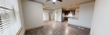 This contemporary 650 square foot apartment offers a thoughtfully designed living space. The open-concept layout maximizes the use of space, creating a seamless flow between the living area and kitchen. The kitchen is a highlight, boasting dark wood cabinetry, stainless steel appliances, and a sleek subway tile backsplash. Granite countertops add a touch of elegance, while a breakfast bar provides additional seating and workspace.

The spacious bedroom, measuring 130 square feet, features plush carpeting and a large window that floods the room with natural light. A ceiling fan ensures comfort year-round. The bathroom, though not pictured, likely continues the modern aesthetic found throughout the apartment.

Storage is ample, with a walk-in closet offering built-in shelving and hanging space. Throughout the apartment, you'll find a mix of durable wood-look flooring and soft carpeting. Large windows with horizontal blinds are present in multiple rooms, allowing for abundant natural light and easy light control.

The apartment's neutral color palette creates a blank canvas for personal style, while features like recessed lighting and stylish pendant fixtures add character. This well-designed space efficiently accommodates all the necessities of modern living within its compact footprint.