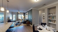 This thoughtfully designed two-bedroom, two-bathroom residence in Spring, Texas, offers a single-story layout that balances modern aesthetics with functional living. Wood-style flooring and crown molding flow throughout, creating a cohesive and polished atmosphere.

The open-concept living and dining area serves as the heart of the home. The living room features a bold deep-green accent wall, ceiling fan, and natural light from large windows dressed in patterned curtains. A dedicated dining space accommodates a round table and connects seamlessly to the kitchen, which is equipped with stainless steel appliances, dark cabinetry, a granite-topped island with a sink, tile backsplash, and track lighting.

Each bedroom offers a distinct character. The primary bedroom presents a lighter, neutral palette with crown molding, a ceiling fan, and ample natural light, while the second bedroom features a dramatic dark accent wall. The primary bathroom includes a glass-enclosed walk-in shower, granite vanity, and access to a walk-in closet. The secondary bathroom offers a full soaking tub with a shower combination and granite countertops.