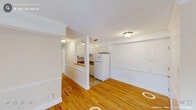Located at 2748 Campus Walk Ave in Durham, NC, this two-bedroom, one-bathroom residence offers a practical and comfortable single-floor layout. Warm hardwood flooring runs throughout the main living areas and bedrooms, complementing the clean white walls and classic trim details including crown molding and chair rail accents.

The open living room receives generous natural light through a large sliding glass door and an adjacent window, both dressed with vertical blinds. A half-wall partition separates the living area from the kitchen, which features white cabinetry, a full-size refrigerator, a sink, and tile flooring — providing a functional and efficient workspace.

Both bedrooms are well-proportioned and bright, each featuring hardwood floors and windows that allow natural light to fill the rooms. The primary bedroom offers a comfortable, spacious footprint. The full bathroom includes a tub-shower combination with built-in shelving and clean, neutral finishes.

A dedicated in-unit laundry room houses a full-size washer and dryer side by side, along with built-in shelving for added storage. The overall aesthetic throughout the home is clean and understated, with a neutral color palette that creates a bright, move-in-ready environment well-suited for everyday living in Durham, NC.