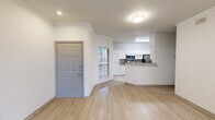 This thoughtfully designed 1-bedroom, 1-bathroom residence offers a comfortable and functional single-floor layout. The open-concept living and kitchen area greets you upon entry, where light wood-tone flooring, crown molding, and recessed lighting create a clean, modern aesthetic. The kitchen is equipped with stainless steel appliances—including a refrigerator, microwave, and range—complemented by granite countertops, white cabinetry, and a breakfast bar that opens to the living area. Natural light filters in through multiple windows fitted with blinds throughout the space.

The living room is generously sized, featuring crown molding, a ceiling fan, and a set of glass double doors that provide direct outdoor access and picturesque views of the surrounding greenery. A secondary entrance from the living area also connects to the bedroom wing.

The bedroom offers plush carpeting, a ceiling fan with light, and large windows that invite natural light and outdoor views. It connects directly to a spacious walk-in closet outfitted with wire shelving systems for ample storage.

The full bathroom is clean and bright, featuring tile flooring, a double-sink vanity with white cabinetry, a large mirror, and a full tub-shower combination. The layout is efficient and well-organized, making this space both practical and inviting throughout.