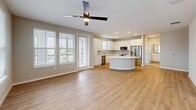 Located in Oviedo, FL, this well-designed 2-bedroom, 3-bathroom single-story home offers a thoughtfully planned layout with modern finishes throughout. The open-concept living and kitchen area serves as the heart of the home, featuring light wood-look flooring, recessed lighting, and a ceiling fan. The kitchen is equipped with white shaker-style cabinetry, a sleek tile backsplash, stainless steel appliances including a refrigerator, dishwasher, and microwave, and a curved central island with a white quartz countertop that provides additional prep and seating space. Large windows flood the living area with natural light and offer views of the surrounding neighborhood. The primary bedroom is generously sized, outfitted with plush carpet flooring, a ceiling fan, and ample natural light from dual windows. The en-suite primary bathroom features white cabinetry with quartz countertops, a tiled tub-shower combination, and direct access to a dedicated walk-in closet fitted with wire shelving. The second bedroom also features soft carpet flooring, a ceiling fan, and neighborhood views. Three full bathrooms ensure convenience for residents and guests alike. The walk-in closet offers organized wire-rack storage on warm wood-look flooring, completing this functional and contemporary home.