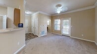 Located at 838 Walden Creek Way in Greenville, South Carolina, this single-story residence offers a well-organized layout designed for comfortable living. The main living area is generously sized, finished with plush carpet and adorned with elegant crown molding. A ceiling fan provides year-round comfort, while a exterior door with an adjacent window invites natural light and provides outdoor access. Multiple closets near the entry offer ample storage from the moment you step inside.

The open layout connects the living area to a dining space, highlighted by a chandelier overhead and a breakfast bar that transitions into the galley-style kitchen. The kitchen features warm wood cabinetry, laminate countertops, hardwood-style flooring, and black appliances including a range and refrigerator, all arranged efficiently for ease of use.

The bedrooms are carpeted and bright, each equipped with ceiling fans and windows that bring in natural light. The bedrooms are well-proportioned, offering comfortable retreats with easy access to storage. The bathroom includes a tub-shower combination, a wood-toned vanity with a light countertop, and hardwood-style flooring, creating a clean, functional space. Throughout the residence, neutral warm tones create a cohesive and inviting ambiance.