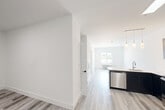 Unit 214 at 102 Washington Ave in Belleville, NJ is a thoughtfully designed 2-bedroom, 1-bathroom residence offering a bright and modern living experience. Light wood-style flooring and crisp white walls run throughout, creating a cohesive, contemporary aesthetic.

The open-concept kitchen is a standout feature, equipped with stainless steel appliances including a refrigerator, range, microwave, and dishwasher. Sleek two-tone cabinetry — dark lower cabinets paired with gray uppers — is complemented by white quartz countertops, a tile backsplash, and pendant lighting over the kitchen island, which also features a built-in sink.

The living area is generously proportioned, with clean lines and ample wall space. Both bedrooms offer comfortable accommodations with the same light flooring; the primary bedroom is notably spacious and features dual closets for excellent storage. The second bedroom benefits from a large window with outdoor views and a wall-unit HVAC system.

The bathroom is finished with large-format white tile surrounding a soaking tub and shower combination, accented by chrome fixtures for a clean, polished look. A stacked washer/dryer unit is also included within the unit. Overall, the space presents a move-in ready, modern environment ideal for everyday living.
