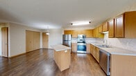 Located at 535 Northland Dr in Saint Joseph, MN, this single-floor, 3-bedroom, 1-bathroom unit offers a practical and comfortable layout. The open-concept kitchen and living area forms the heart of the space, featuring warm honey-toned cabinetry, stainless steel appliances including a refrigerator, range, microwave, and dishwasher, a central island with a light countertop, and durable hardwood-style flooring. A pendant light fixture adds a finishing touch to the kitchen area. The living room is bright and open, with natural light streaming through a large window that frames views of the surrounding landscape. The three bedrooms are carpeted for comfort, each offering closet storage — with one bedroom featuring a full-width bifold closet — and windows with outdoor views of open green space. The full bathroom includes a wide vanity with a double sink, wood cabinetry, and hardwood-style flooring. Additional features include in-unit laundry, five closets providing ample storage, baseboard heating throughout, and a textured ceiling finish. The single-floor layout ensures easy accessibility throughout, making this a well-equipped and functional living space in a quiet Minnesota setting.