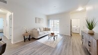Located at 1031 S Crismon Rd in Mesa, AZ, this single-floor, 3-bedroom, 2-bathroom home offers a well-designed layout with modern finishes throughout. Wood-style flooring runs consistently across the living spaces, tying the home together with a clean, contemporary aesthetic. The bright living room features sliding glass doors that open to a private balcony, filling the space with natural light and providing outdoor views. Adjacent to the living room, the dedicated dining area offers a comfortable space for meals, while the galley-style kitchen is equipped with stainless steel appliances, light wood cabinetry, and ample counter space. The spacious primary bedroom includes a ceiling fan and a well-sized closet, while the two additional bedrooms each offer closet storage and natural light. Both bathrooms feature light wood vanities with white countertops and wood-style flooring, maintaining a cohesive design throughout. One bathroom includes a tub/shower combination, while the other features an extended vanity layout. A dedicated laundry room with an in-unit washer and water heater adds everyday convenience. Neutral wall tones and clean lines throughout the home create a calm, functional living environment.