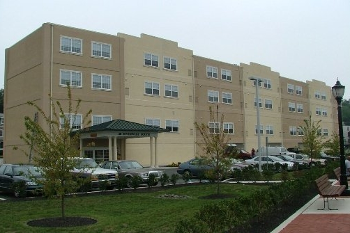 Building Photo with Parking - Riverwalk Senior Apartments