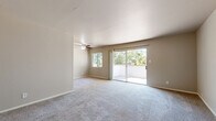 Located at 2666 Cottage Way in Arden-Arcade, California, this 2-bedroom, 1-bathroom residence offers a well-organized single-floor layout designed for comfortable everyday living. The living room is generously sized, featuring soft carpeting, a ceiling fan, and abundant natural light from multiple windows. A sliding glass door opens directly onto a private balcony that overlooks lush tree canopy, creating a pleasant indoor-outdoor connection. The living area flows seamlessly into a dedicated dining room, ideal for shared meals and entertaining. The kitchen is positioned conveniently adjacent to the dining space. Both bedrooms are carpeted and feature neutral tones, with natural light provided by well-placed windows. The primary bedroom is notably spacious and includes a mirrored sliding-door closet that adds both storage and a sense of depth to the room. The second bedroom also benefits from natural light and offers comfortable proportions. Three closets throughout the unit ensure ample storage. The bathroom is cleanly finished with tile flooring, a tub-shower combination with white tile surround, and a vanity. A hallway connects the private areas of the home, contributing to a practical and efficient floor plan throughout.