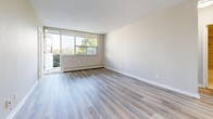 Located on Merton Street in Toronto's sought-after Davisville Village neighbourhood, this 2-bedroom, 1-bathroom unit offers a clean, modern living environment across a single floor. The open living room is a standout space, featuring light grey laminate flooring, neutral-toned walls, and expansive floor-to-ceiling windows that flood the room with natural light. A sliding glass door provides access to a private balcony overlooking lush greenery, enhancing the sense of openness. Baseboard heating runs beneath the windows throughout the unit, ensuring year-round comfort. The primary bedroom is generously sized, offering a large sliding-door closet for ample storage, and is complemented by a second bedroom with its own closet and a bright window framing views of the surrounding neighbourhood and cityscape. The kitchen is functionally designed with tile flooring and features a stainless steel range with an overhead exhaust hood. The bathroom is elegantly finished with marble-effect wall tiles surrounding a full soaker tub with a handheld shower fixture. A connecting hallway ties all rooms together efficiently, completing this well-appointed urban residence.