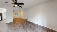 Located at 829 NW 79th Ter in Kansas City, MO, this two-bedroom, two-bathroom unit offers a well-organized single-floor layout designed for comfortable everyday living. The open living room is highlighted by durable hardwood-style flooring, a ceiling fan with light fixture, and a textured ceiling. A sliding glass door leads to a private balcony, allowing natural light to fill the space and offering outdoor views of surrounding greenery. The galley-style kitchen features abundant white cabinetry, white countertops, a stainless steel sink, a black electric range, a dishwasher, and a refrigerator — all flowing toward the living area with a clear sightline to the balcony. Both bedrooms are carpeted and receive natural light through windows. The primary bedroom includes mirrored sliding closet doors, adding depth to the room. A second bedroom provides a quiet, comfortable retreat. The two bathrooms are cleanly appointed — one with a tub/shower combo and wood-style flooring, and the other featuring a white vanity with mirror cabinet storage. A connecting hallway ties all rooms together efficiently, completing this practical and neatly presented home.