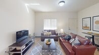 This 850 square foot single-story home in Reno, NV offers a thoughtful layout with 3 bedrooms and 2 bathrooms. The open-concept design combines the kitchen and living area, maximizing the use of space. The kitchen features modern wood cabinetry, black appliances, and ample counter space. The living room is comfortably furnished with a leather sofa and loveseat, centered around a sleek entertainment unit.

The primary bedroom, measuring 160 square feet, includes a mirrored closet and space for a work area. All bedrooms have carpeted floors, while the main living areas and bathrooms feature durable wood-look flooring. The bathrooms are efficiently designed with modern fixtures and adequate storage.

A dedicated laundry area with a stacked washer and dryer adds convenience. Throughout the home, large windows allow natural light to brighten the spaces. The neutral color palette and contemporary artwork create a cohesive, modern ambiance. Despite its compact size, this home offers functionality and style, making efficient use of every square foot.