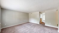 Located at 231 W Monument Ave in Dayton, Ohio, this single-floor unit offers two bedrooms and two bathrooms in a well-organized layout. The expansive living room features neutral-toned carpet, textured ceilings, and clean white baseboards, creating a bright and open atmosphere. The space flows naturally toward the kitchen, which is finished with warm wood cabinetry, dark countertops, a tile backsplash, and hexagonal tile flooring. Black appliances — including a refrigerator, dishwasher, and range — are complemented by track lighting overhead.

The primary bedroom is a generously sized retreat with soft carpeting and a large bi-fold closet for ample storage. A dedicated walk-in closet with wire shelving provides additional organization space. The second bedroom also features carpet flooring and a window that brings in natural light with outdoor views. Both bathrooms are well-appointed; one includes a wood-toned vanity with a dark countertop, a tiled tub-shower combo, and wood-look vinyl flooring. A connecting hallway ties the rooms together efficiently, completing this functional and comfortable single-floor residence.