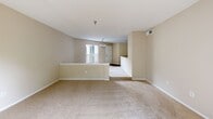 Located at 4550 47th St W in Bradenton, Florida, this two-bedroom, one-bathroom residence offers comfortable single-floor living with a well-considered layout. The open living area features plush wall-to-wall carpeting, neutral beige tones, and a sliding glass door that leads directly to a private balcony overlooking mature, lush greenery — bringing natural light and outdoor views into the heart of the home. A chandelier accent adds a touch of elegance to the entryway-adjacent dining space.

Both bedrooms are carpeted and finished with the same warm neutral palette. Each room is equipped with a ceiling fan and includes windows that invite natural light and outdoor views. The primary bedroom is a well-proportioned retreat with a closet, while the second bedroom offers similar comfort with its own window and closet access.

The kitchen features dark granite-style countertops contrasting with white cabinetry and wood-tone flooring, providing a functional and visually appealing workspace. The bathroom is finished with tile flooring, a granite-topped vanity with white cabinetry, a large mirror, and a full tub-shower combination with white tile surround. The overall ambiance throughout the unit is clean, bright, and move-in ready, making it a practical and inviting Florida residence.