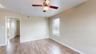 Located at 1114 W 26th St in Houston's desirable Timbergrove/Lazybrook neighborhood, this one-bedroom, one-bathroom home offers a smartly designed single-floor layout with wood-look flooring running throughout every room. The open-concept kitchen and living area serves as the heart of the home, where a well-appointed kitchen impresses with rich dark-stained cabinetry reaching toward the ceiling, granite countertops, a peninsula breakfast bar with pendant lighting overhead, and a full suite of stainless steel appliances including a refrigerator, range, and built-in microwave. Natural light filters in through multiple windows fitted with blinds, keeping the space bright and welcoming. The spacious bedroom features a ceiling fan with light fixture, neutral-toned walls, and generous natural light. A standout feature of the bedroom is the dual closets, providing ample storage. The bathroom is finished with large-format travertine-style tile surrounding a full soaking tub and shower combination, complemented by a window for added ventilation and light. Clean white trim and warm neutral paint tones create a consistent, cohesive aesthetic throughout this efficiently laid-out Houston home.
