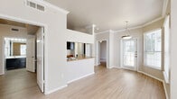Located at 801 Legacy Dr in Plano, TX, this two-bedroom, three-bathroom residence offers a well-designed single-floor layout that maximizes functionality and comfort. Light wood-style flooring runs throughout the home, complemented by crisp crown molding and neutral warm-toned walls that create a cohesive, inviting ambiance.

The open living and dining area is bright and airy, anchored by a bay window and a glass-paned entry door that flood the space with natural light. A pendant light fixture adds a refined touch overhead. The kitchen features a pass-through counter with granite-style surfaces, bold dark cabinetry with ample storage, a tile mosaic backsplash, and a full suite of black appliances including a refrigerator, range, dishwasher, and microwave.

The primary bedroom is generously proportioned, offering crown molding, a ceiling fan, and a mirrored sliding-door closet that enhances the sense of space. The secondary bedroom provides a comfortable retreat with a window and easy access to the main living areas. Each bathroom is clean and functional, with dark vanity cabinetry, white countertops, and tiled tub-shower combinations. A dedicated in-unit laundry closet with a full-size washer and dryer adds everyday convenience to this well-appointed Plano residence.