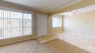 Located at 3335 Artesia Blvd in Torrance, CA, this single-floor unit offers a well-organized layout with a warm, neutral color palette throughout. The entryway welcomes you with tile flooring and large windows that fill the space with natural light, complemented by a ceiling fan overhead. Crown molding is a consistent architectural detail present across the living areas, adding a polished finish to each room.

The living area is generously sized, featuring plush carpeting and an open connection to the kitchen, which is outfitted with white cabinetry, granite countertops, tile flooring, and black appliances including a range and microwave. The kitchen's efficient layout maximizes storage and counter space.

The bedrooms are carpeted and bright, each featuring crown molding and windows with vertical blinds that allow natural light to filter through. One bedroom includes a mirrored sliding-door closet, offering both storage and a sense of added depth.

The unit includes two bathrooms: one featuring a tub-shower combination with white tile surround and a wood-toned vanity with granite countertop, and a second with a standalone shower stall. Both bathrooms are finished with tile flooring and warm-toned walls, maintaining the cohesive aesthetic found throughout the home.