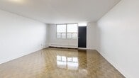 Located on the 14th floor at 2460 Weston Road in Toronto's west end, this 2-bedroom, 1-bathroom unit offers a functional and well-organized layout across a comfortable footprint. The open-concept living and dining area is bright and spacious, featuring classic parquet wood flooring that extends throughout the unit, crisp white walls, and large windows that bring in natural light while offering elevated city views. Baseboard heating runs along the perimeter of the main living space.

The kitchen is well-equipped with white shaker-style cabinetry, a herringbone tile backsplash, dark countertops, stainless steel appliances including a fridge, stove, and over-the-range microwave, and light tile flooring. A peninsula-style counter with a dark top separates the kitchen from the living area, providing additional prep space.

Both bedrooms continue the parquet flooring theme and are served by natural light through large windows with views of the surrounding neighbourhood. The primary bedroom includes a mirrored sliding-door closet. The bathroom features a full-sized soaker tub and shower combo surrounded by clean white subway tile, offering a bright, timeless finish. A hallway connects all rooms efficiently, completing this practical and move-in ready unit.