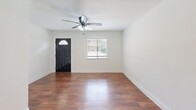 Located on Grover Ave in Austin's 78756 zip code, this one-bedroom, one-bathroom single-story home offers a well-organized layout designed for efficient, comfortable living. Rich hardwood-style flooring flows throughout, complemented by crisp white walls and clean baseboards that give the interior a bright, cohesive feel.

The living room serves as the welcoming heart of the home, featuring a ceiling fan with light fixture, a front door with an arched transom window, and a side window fitted with blinds that allow for natural light and privacy control. The kitchen is well-appointed with stainless steel appliances — including a gas range, microwave, and full-size refrigerator — paired with granite-look countertops, taupe cabinetry, and a sputnik-style ceiling light fixture. A window above the counter brings in additional natural light.

The bedroom is a comfortable retreat featuring a ceiling fan, hardwood-style flooring, a window with blinds, and notably, dual closets with hanging rods — offering generous storage rarely found in a home of this size. The bathroom includes a full tub and shower combination with large-format beige tiles and a decorative mosaic tile border accent, adding a refined touch to the space.