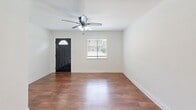 Located on Grover Ave in Austin's 78756 zip code, this one-bedroom, one-bathroom single-story home offers a well-organized layout designed for efficient, comfortable living. Rich hardwood-style flooring flows throughout, complemented by crisp white walls and clean baseboards that give the interior a bright, cohesive feel.

The living room serves as the welcoming heart of the home, featuring a ceiling fan with light fixture, a front door with an arched transom window, and a side window fitted with blinds that allow for natural light and privacy control. The kitchen is well-appointed with stainless steel appliances — including a gas range, microwave, and full-size refrigerator — paired with granite-look countertops, taupe cabinetry, and a sputnik-style ceiling light fixture. A window above the counter brings in additional natural light.

The bedroom is a comfortable retreat featuring a ceiling fan, hardwood-style flooring, a window with blinds, and notably, dual closets with hanging rods — offering generous storage rarely found in a home of this size. The bathroom includes a full tub and shower combination with large-format beige tiles and a decorative mosaic tile border accent, adding a refined touch to the space.