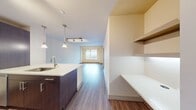 This contemporary 600 square foot apartment offers a harmonious blend of style and functionality. The open-concept design seamlessly integrates the living room and kitchen, creating a spacious feel. The gourmet kitchen boasts stainless steel appliances, dark wood cabinetry, and a large island with a quartz countertop, perfect for meal preparation and casual dining.

The bedroom, measuring 130 square feet, features warm wood flooring and a large window that floods the space with natural light, offering stunning city views. A well-designed closet provides ample storage space with adjustable shelving and hanging areas.

The bathroom is a model of modern elegance, with a sleek vanity, large mirror, and a combination tub-shower. Neutral tones and quality fixtures create a spa-like atmosphere.

Throughout the apartment, track lighting and pendant fixtures provide adjustable illumination. The unit's strategic layout maximizes every square foot, offering a comfortable living space without sacrificing style. Located at 100 Pier 4, this one-bedroom apartment combines urban sophistication with practical living, making it an ideal home for the discerning city dweller.